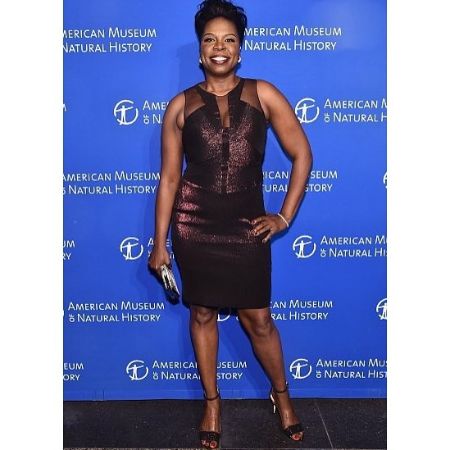Leslie Jones in a black dress poses a picture.